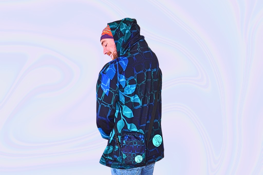 Back view of a person wearing a gradient blue and pink hoodie, standing against a dark, fluid neon background.